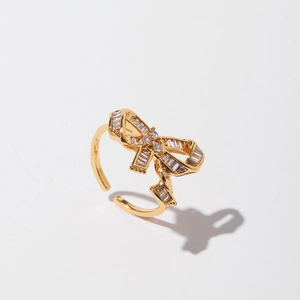 Close-up of golden bow-knot ring with zircon inlay and adjustable open band design