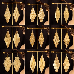 Set of nine gold baroque earrings with leaf and heart shapes on display