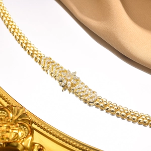 Macro detail of a golden zircon flower pendant with a multi-row beaded chain necklace