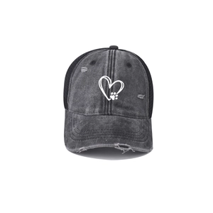 Close-up of heart and paw print embroidery on distressed washed denim baseball cap