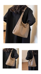 Detail view of the brown PU leather texture and adjustable strap on this vintage tote bag