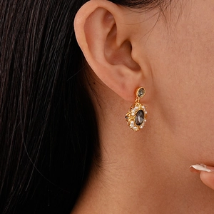 Vintage gold plated earrings with black oval stone and pearls shown on a female model