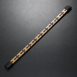 Detail of light brown leather bracelet featuring black cross patterns and magnetic buckle