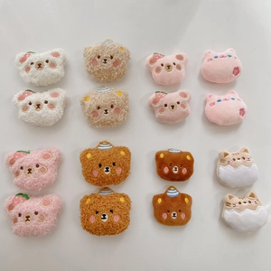 Close-up of assorted plush cartoon bear and cat charms for DIY accessories and badges