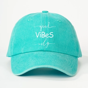 Detail view of mint green cotton baseball cap with white good ViBeS only embroidery