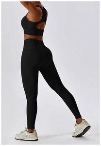 Détail d'un ensemble de yoga noir côtelé avec brassière dos croisé et legging taille haute