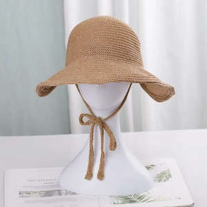 Detail of hand-woven straw bucket hat with adjustable chin strap on a mannequin
