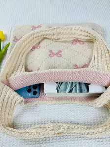 Top view of cream knit tote bag with pink bows showing spacious interior and storage capacity
