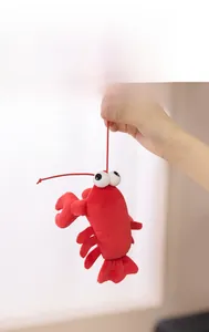 Close-up of red plush lobster toy with large white eyes and elastic lanyard detail
