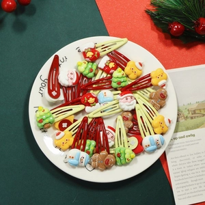 Cute Christmas hair clips for kids with Santa, snowman and reindeer designs on a plate