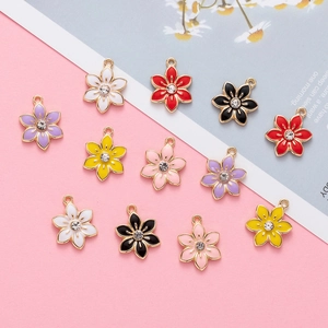 Flat lay of colorful enamel flower charms with zircon centers for jewelry making
