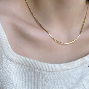 Close-up of 3mm gold titanium steel snake bone chain necklace on a female neck