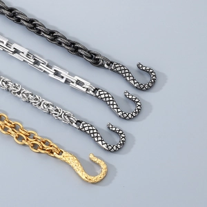 Detailed macro view of four snake-textured S-clasps in black, silver, steel, and gold finishes