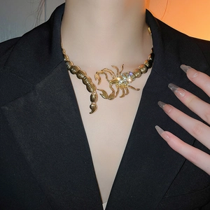 Detailed close-up of a golden scorpion choker necklace featuring sparkling rhinestones