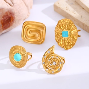 Detail of four bohemian gold rings set with turquoise stones and shimmering zircons
