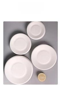 Stack of biodegradable sugarcane pulp plates and bowls with anti-slip texture details