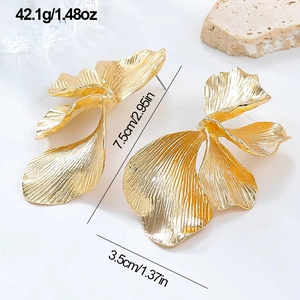 Detail view of large gold leaf earrings showing 7.5cm length and mirror texture
