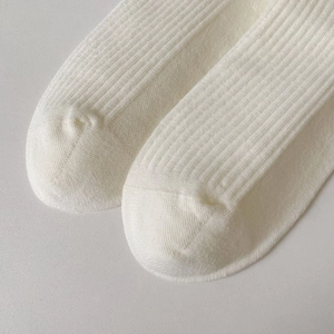 Detailed close-up of high-density cotton knit texture and seamless toe of white sports socks