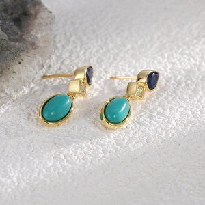Elegant gold drop earrings featuring blue zircon and turquoise stones on a stone background