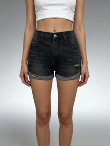 Close-up of black high-waisted denim shorts with distressed frayed hem and ripped details