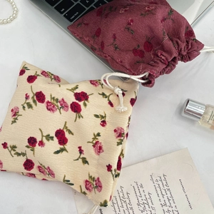 Detail of floral corduroy drawstring pouch with vintage rose patterns for skincare storage