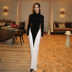 Détail d'une robe ajustée avec coutures contrastées, jupe blanche froncée et manches noires