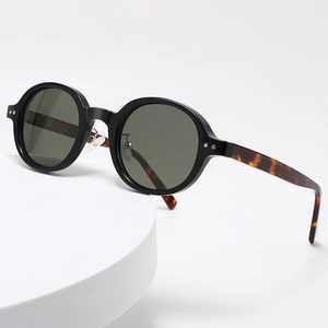 Classic round frame polarized sunglasses with tortoise shell temples on a white tray