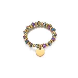 Detail shot of stretch bead ring with gold beads and a dangling polished heart charm