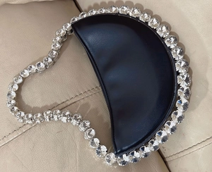 Detailed view of luxury black leather crescent bag with sparkling crystal rhinestones