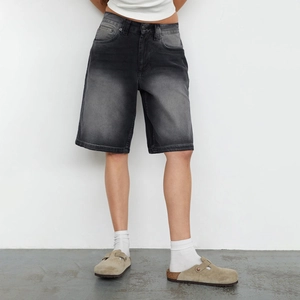 Close-up of washed dark gray denim fabric and texture on slim fit bermuda shorts