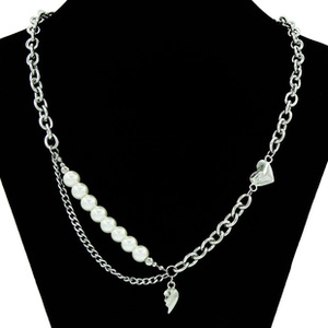 Detail of silver Cuban chain necklace with white pearls and heart pendant on mannequin