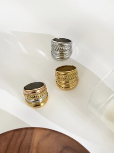 Detailed view of triple-layered titanium steel rings in gold and silver finishes