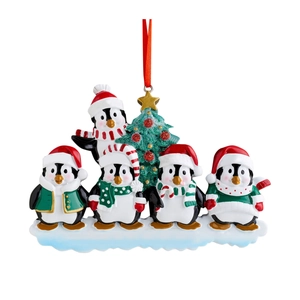 Detail of five penguins with Christmas hats and a glittery tree holiday ornament