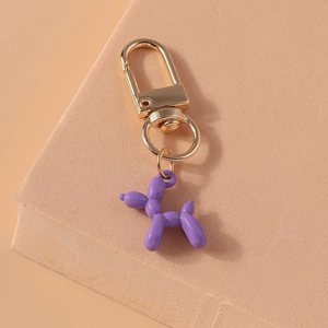 Macro shot of purple balloon dog keychain with shiny finish and golden metal buckle