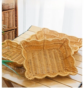 Close-up of woven faux rattan fruit basket tray with wavy edges on wooden table