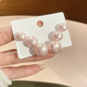 Detail of elegant pink iridescent pearls set on a white holder for versatile jewelry design