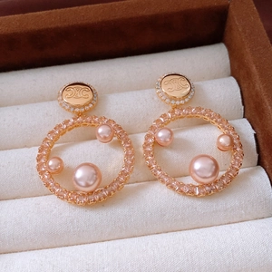 Detail of gold-plated hoop earrings with pink pearls and zircon in a luxury jewelry box