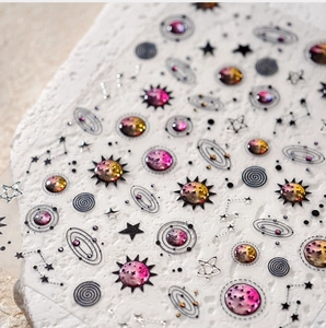 Vue macro d'autocollants 3D pour ongles avec motifs galaxie et planètes dégradées