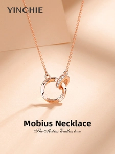 Close-up of rose gold Mobius double ring necklace with fall in Love engraving and pavé crystals