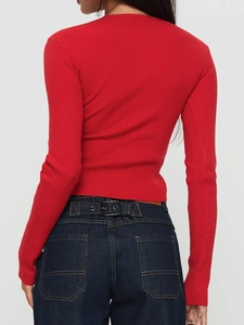 Vue de dos d'un haut rouge à manches longues en maille porté avec un jean en denim bleu