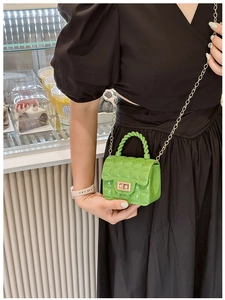 Close-up of bright green quilted jelly bag with gold chain and metal clasp