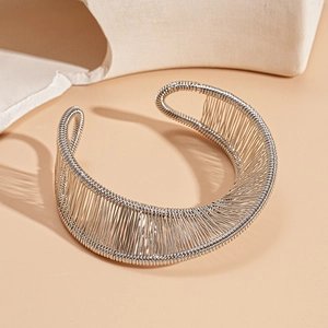 Close-up of artistic silver wire wound metal bangle with intricate geometric floral textures