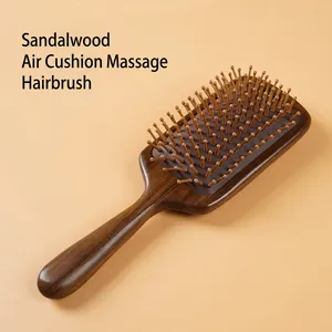 Sandalwood cushion scalp massage comb with natural wood grain on a warm beige background