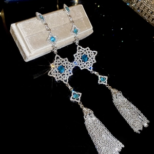 Detail of silver drop earrings with sea blue zircon crystals and elegant tassels