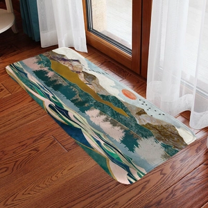 Detail of artistic mountain landscape bath mat on rustic dark wood floor with natural light