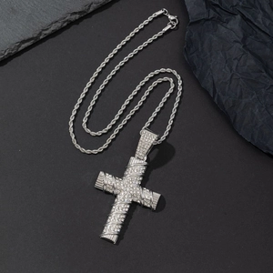 Close-up of silver cross pendant with full diamond inlay on twisted rope chain
