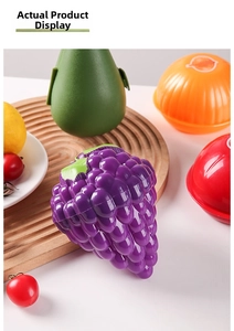 Detail of fruit and vegetable shaped food storage containers on a rustic wooden tray