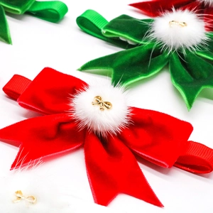 Close-up of velvet Christmas pet bow tie with faux fur ball and golden metal charm