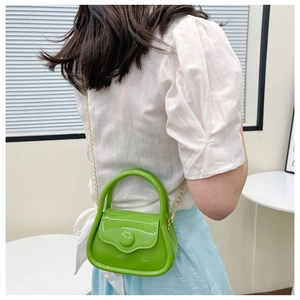 Detailed side view of mini green jelly bag with gold chain strap on model shoulder