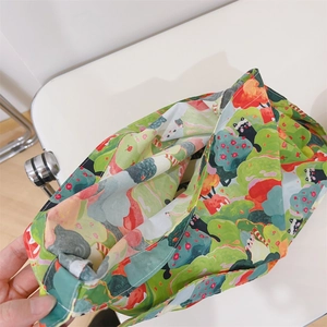 Detail view of cotton crossbody bag featuring green forest print and black cat patterns